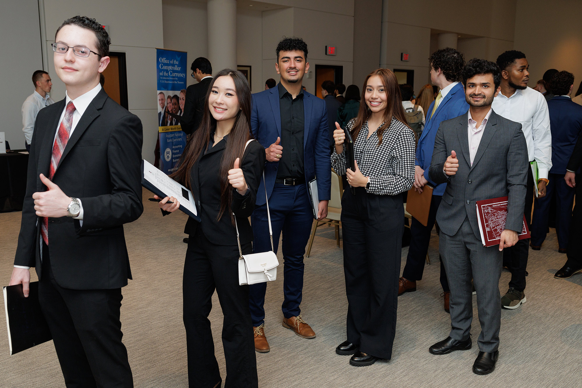Group of male and female students stand in line wearing business attire
