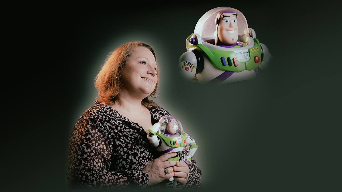 Heather Rodriguez holding Buzz Lightyear and gazing up at Buzz Lightyear