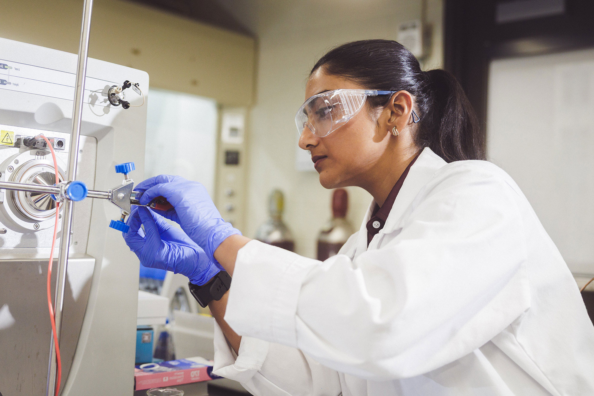 female lab student in glasses and white lab coat