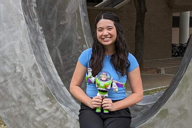 Student Writer Emily Chan '25 holds Buzz Lightyear Figure