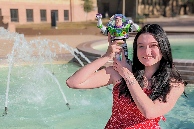 Student Writer Emily Godsey '24 holds Buzz Lightyear Figure
