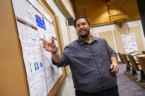 graduate student pointing at chart