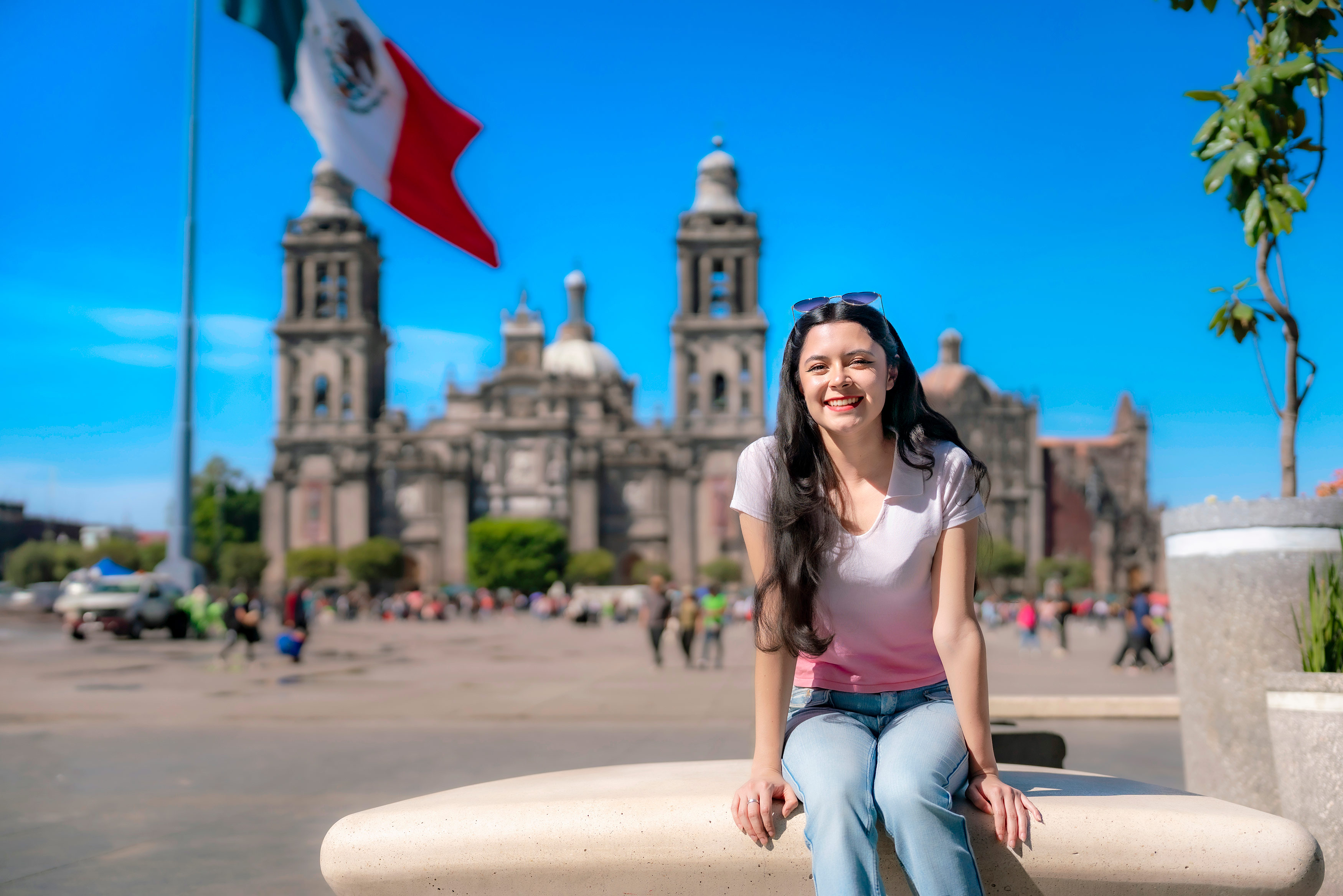 Young woman smiling and sitting outside in front of ancient architecture