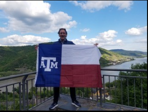 Student holding Aggie flag at Schloss Heidelberg overlooking the town of Heidelberg, Germany.