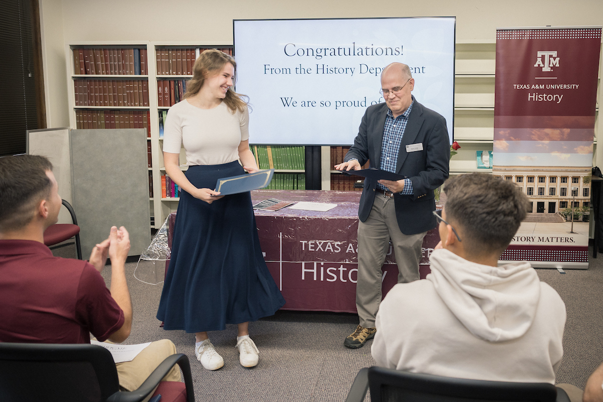 Ryan Holcomb receives her certificate from Dr. Adam Seipp.