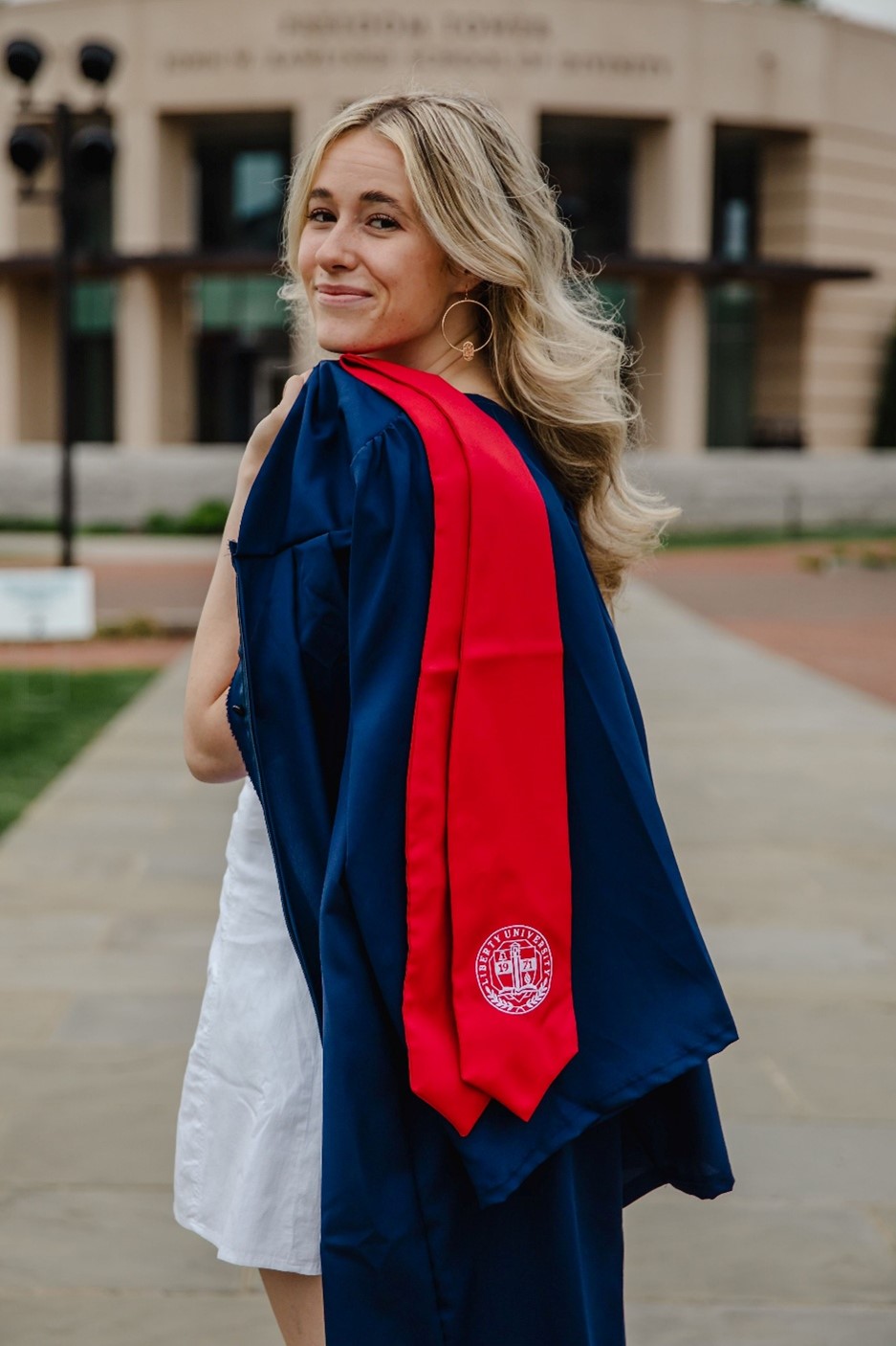 college aged blonde girl looking over left shoulder at the camera