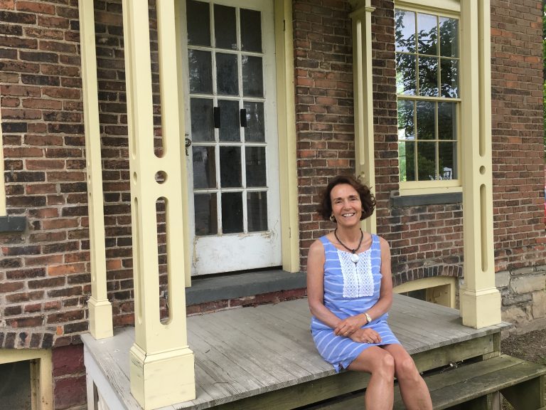 Texas A&M Professor Elizabeth Cobbs sitting on the porch of Harriet Tubman's home.