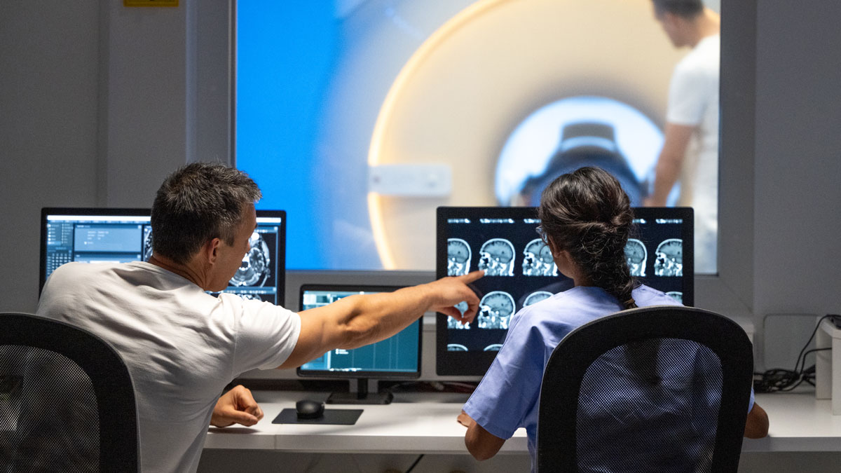 Two medical professionals reading brain scans from a patient's MRI.