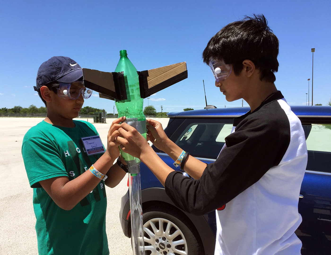 Two high school boys hold a homemade rocket made from a Sprite bottle