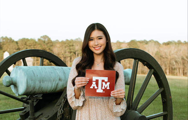 Madelaine Setiawan with a Texas A & M logo in front of an historic cannon