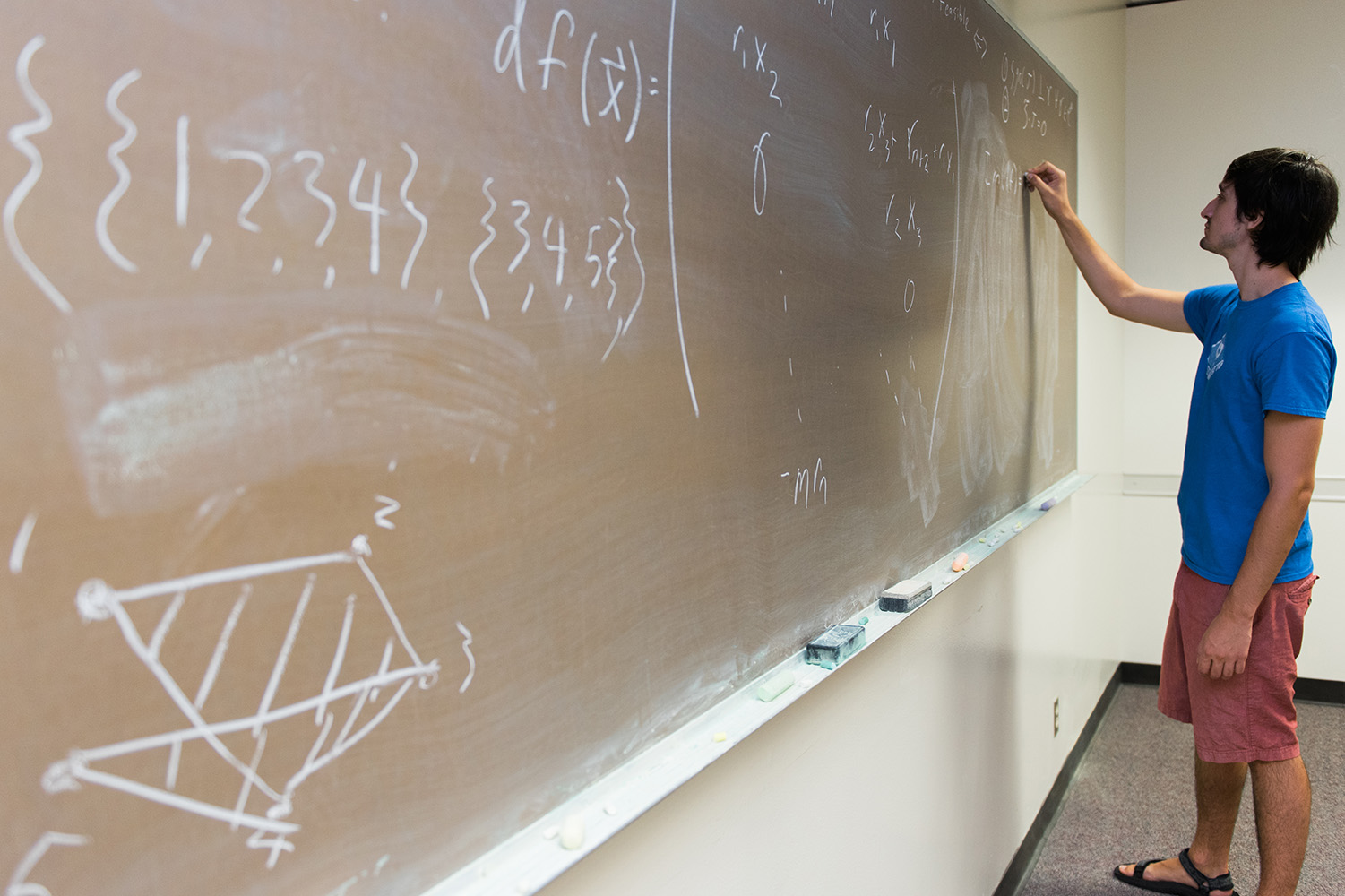 A math major writes equations on a chalkboard
