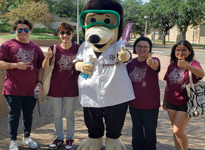 The Texas A&amp;M Chemistry mole poses with several chemistry students at the 2022 Chemistry Open House