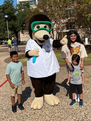 The Chemistry mole poses with three children at the 2022 Texas A&amp;M Chemistry Open House