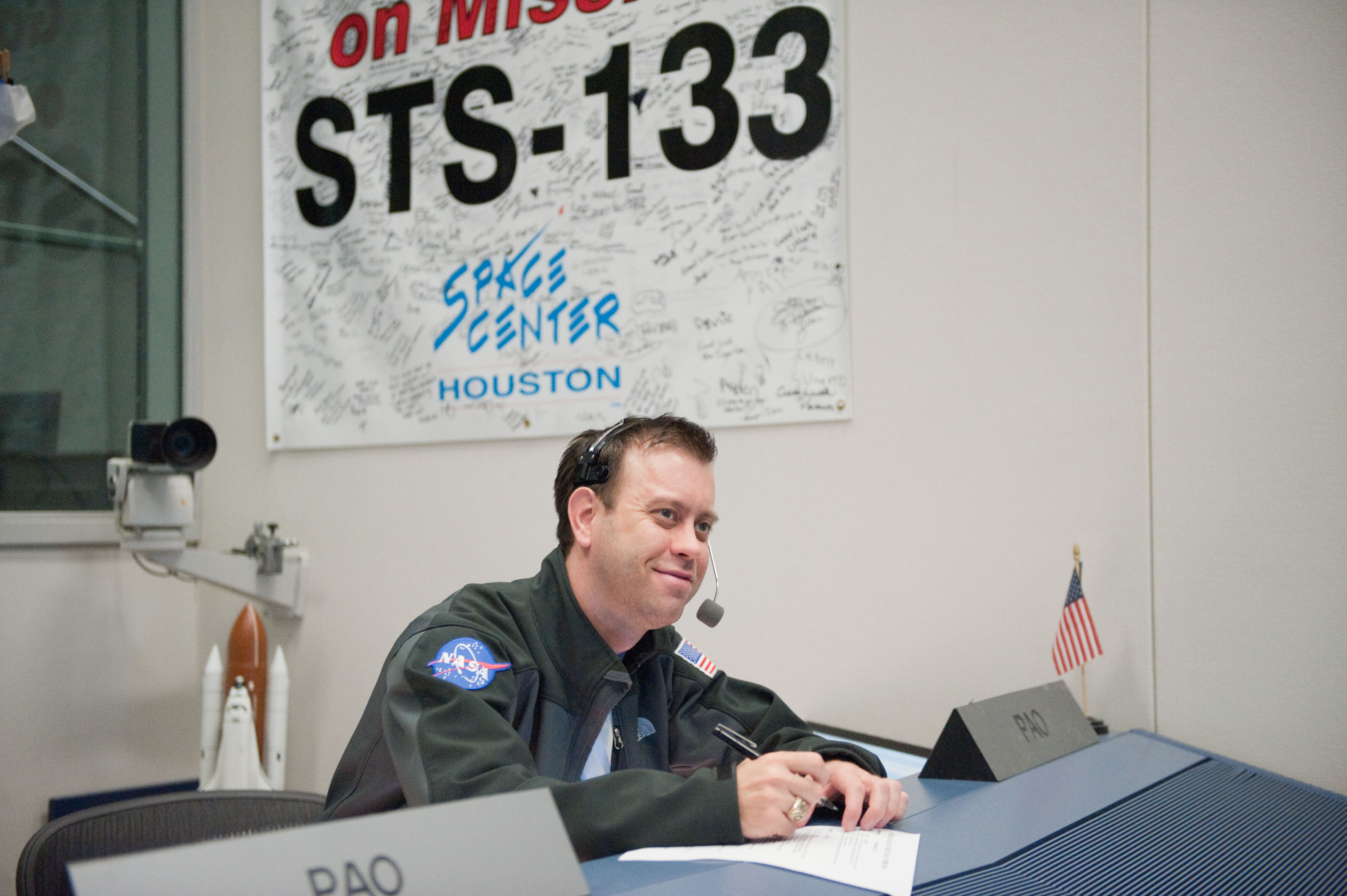1999 Texas A&amp;M journalism graduate Josh Byerly, wearing a headset and with pen and paper at the ready in his role as Public Affairs Officer and the voice of NASA for STS-133 and the final launch of Space Shuttle Discovery in 2011