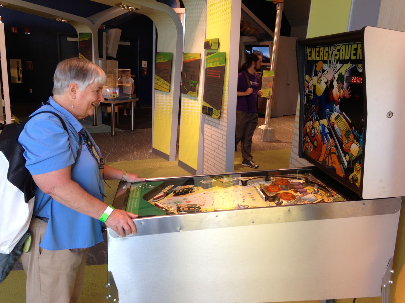 Texas A&amp;M mathematician Sue Geller smiles while playing pinball at MathFest 2013
