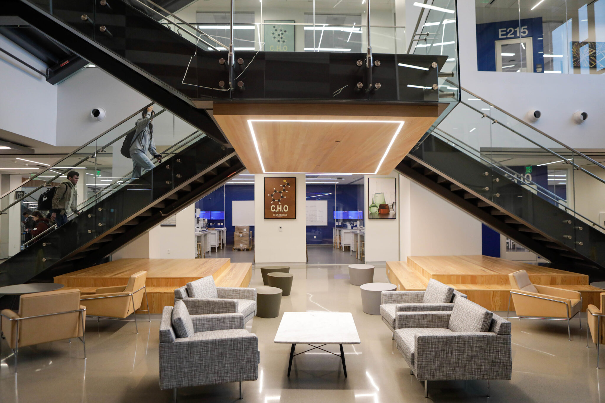 Interior view of the Instructional Laboratory and Innovative Learning Building at Texas A&amp;M University showing students ascending the main staircase in the foyer and various seating areas