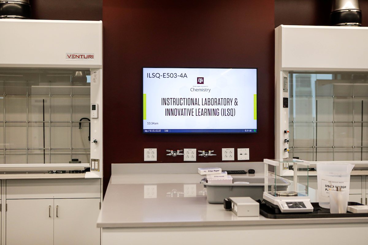 Close-up view of a work station in an organic chemistry laboratory within the Instructional Laboratory and Innovative Learning Building at Texas A&amp;M University featuring a computer, fume hoods and assorted laboratory equipment