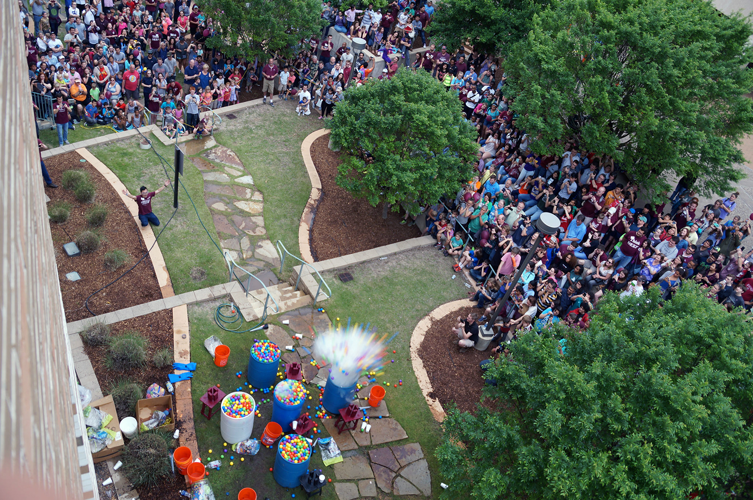 Aerial view of hundreds of spectators watching the colorful water balloon explosion at Physics Festival