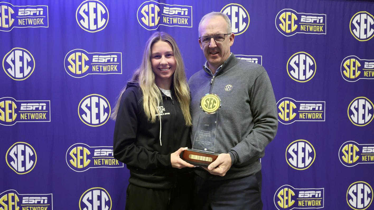 Texas A&amp;M swimmer Chloe Stepanek receives a trophy and congratulations from Southeastern Conference Commissioner Greg Sankey