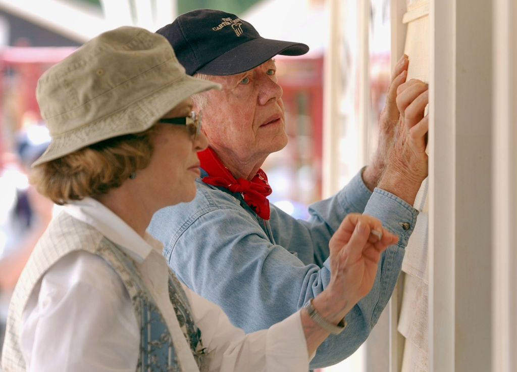 Former U.S. President Jimmy Carter and his wife Rosalyn attach siding to the front of a Habitat for Humanity home being built on June 10, 2003 in LaGrange, Georgia.