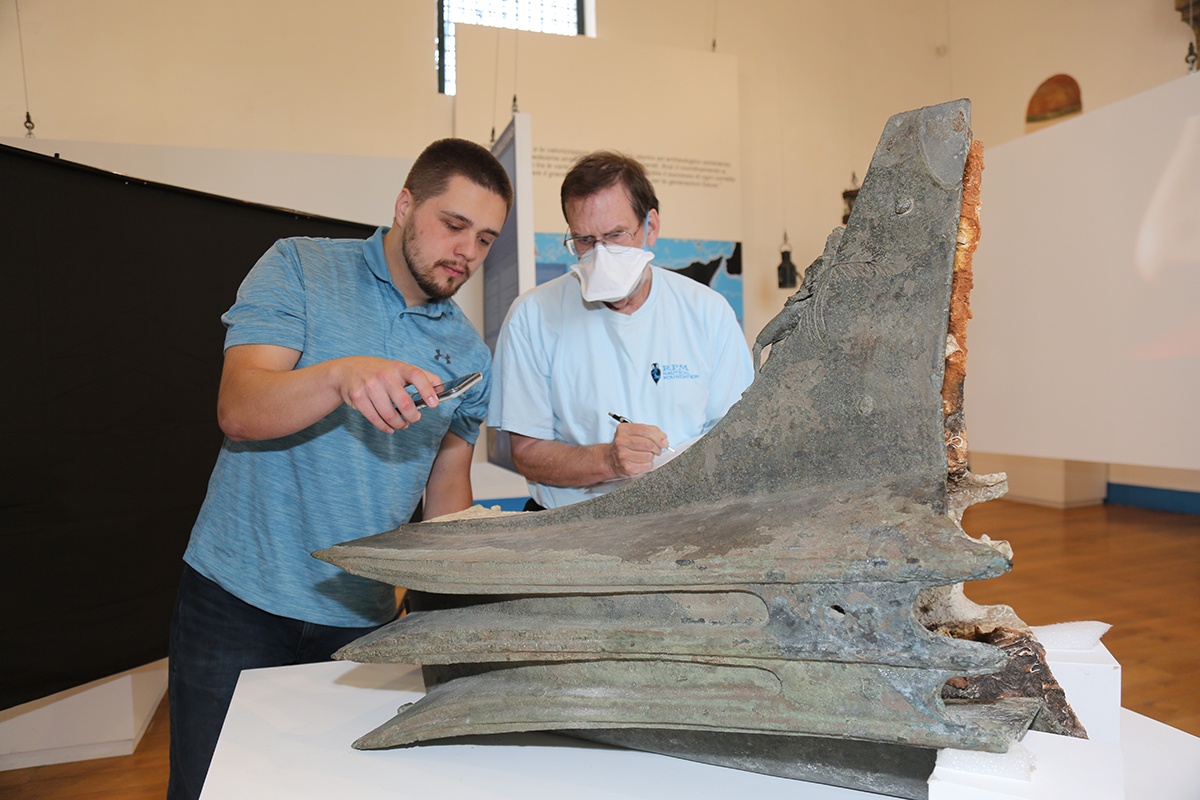 Texas A&amp;M anthropology Ph.D. student Stephen DeCasien studies a naval ram from the Battle of Egadi Islands Project while in Sicily in the summer of 2022
