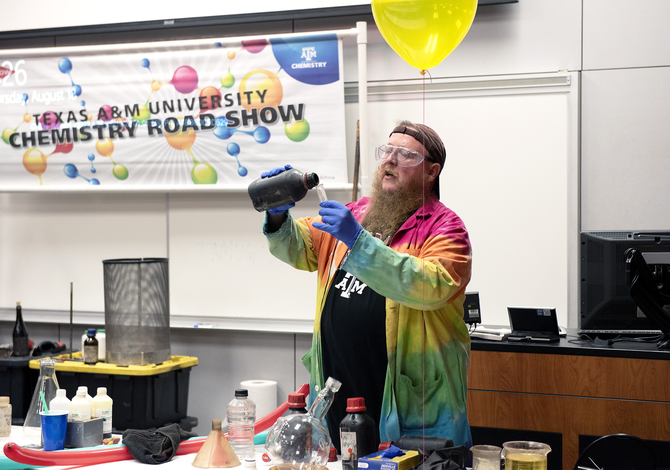 Texas A&amp;M chemist James Pennington pours a solution into a cylinder during the Chemistry Road Show