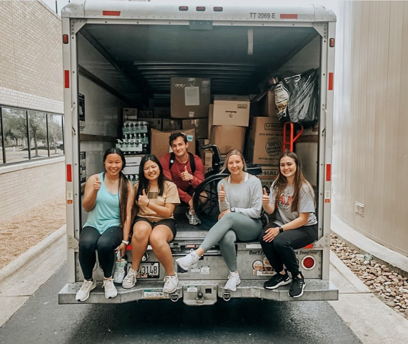 Texas A&amp;M biomedical sciences major Mya Phelps and other VOOM Ambassadors, sitting in the back of a U-Haul full of packaged medical supplies