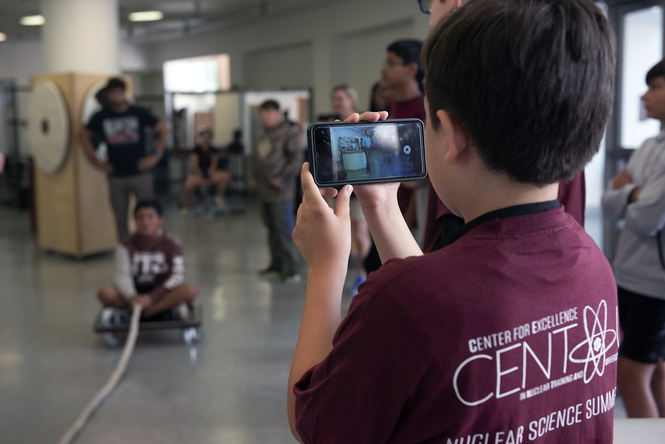 Middle school students wearing maroon CENTAUR t-shirts participate in hands-on science demonstrations during a nuclear science summer camp at Texas A&amp;M University