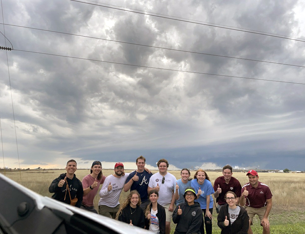 Group photograph of the 2023 Convective Storms Field Studies students and instructors in front of a supercell thunderstorm in Amarillo, Texas