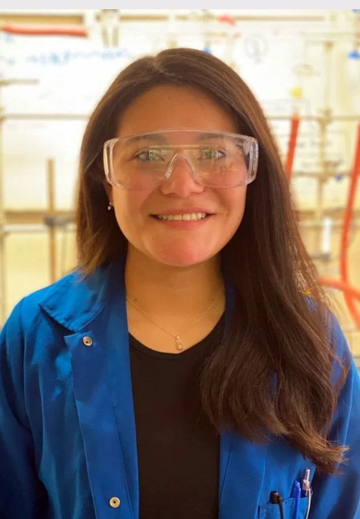 Texas A&amp;M chemistry graduate student Jeanette Piña, wearing clear goggles and a blue lab coat within the Thomas Lab