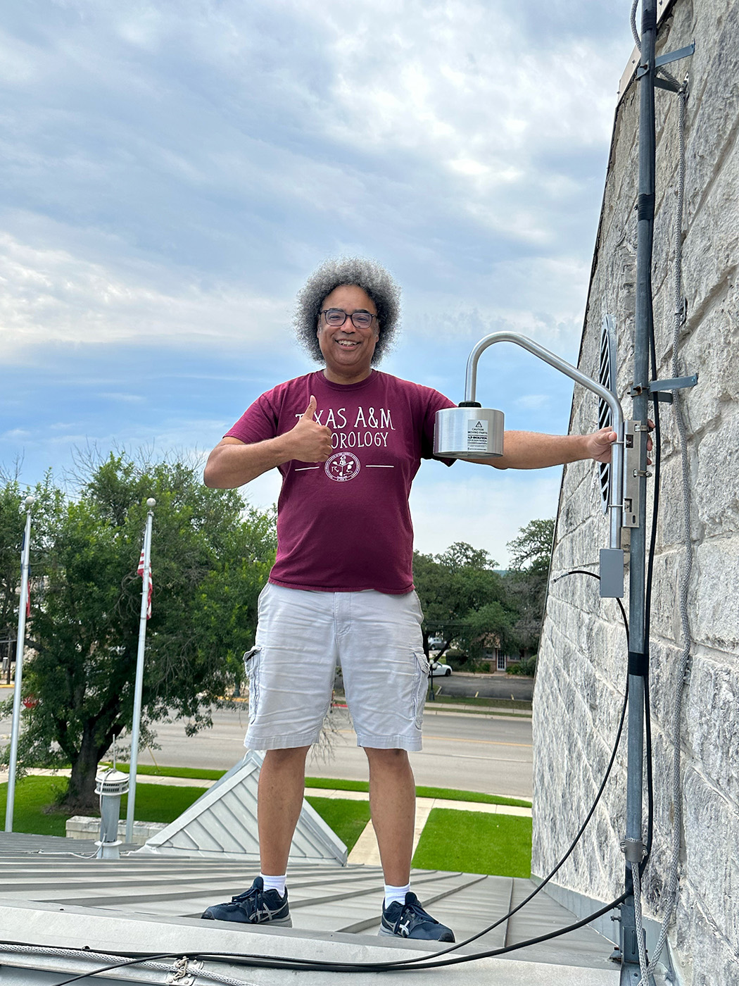 Texas A&amp;M atmospheric scientist Timothy Logan flashes a thumbs up while posing with lightning detection equipment at the Boerne Fire Department in Boerne, Texas