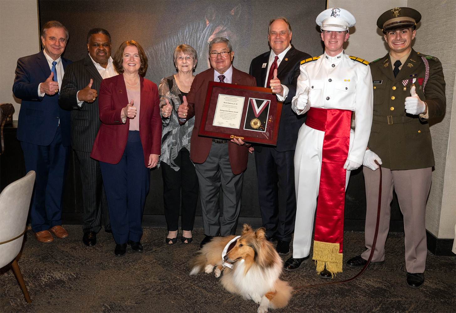 1969 Texas A&amp;M mathematics graduate Hector Gutierrez Jr. and his wife Debbie Gutierrez flash gig 'ems while posing with various Texas A&amp;M administrators during a surprise announcement of his 2023 Texas A&amp;M University Distinguished Alumnus Award honor