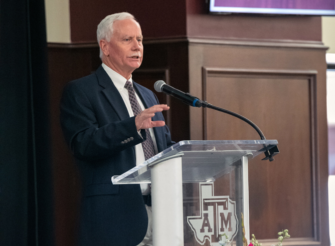 Texas A&amp;M biologist Mark Zoran at the podium in The Zone Club at Kyle Field