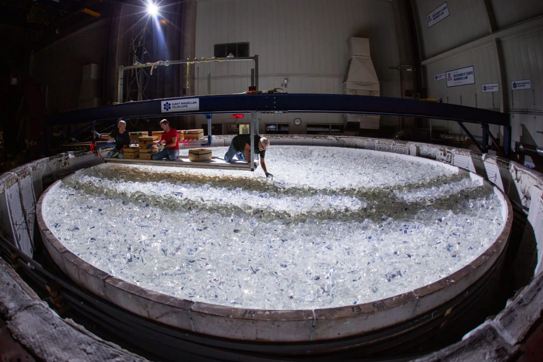 A worker places glass pieces being used to cast a mirror for the Giant Magellan Telescope