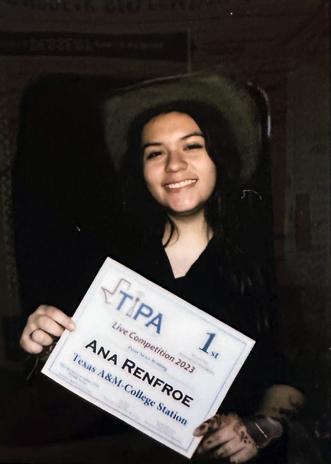 Texas A&amp;M University English major Ana Renfroe smiles for the camera while wearing a cowboy hat and holding her first-place newswriting certificate at the Texas Intercollegiate Press Association 2023 Convention