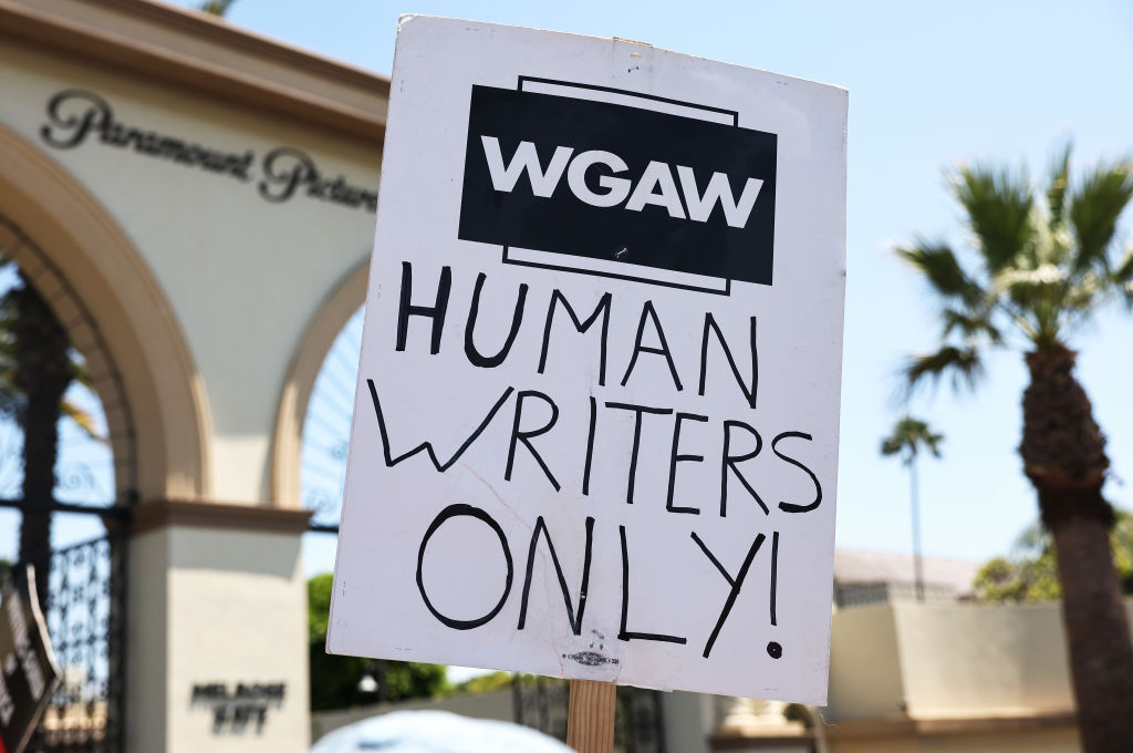 A sign with the words "Human Writers Only!" as striking WGA (Writers Guild of America) workers picket outside Paramount Studios on July 12, 2023 in Los Angeles, California