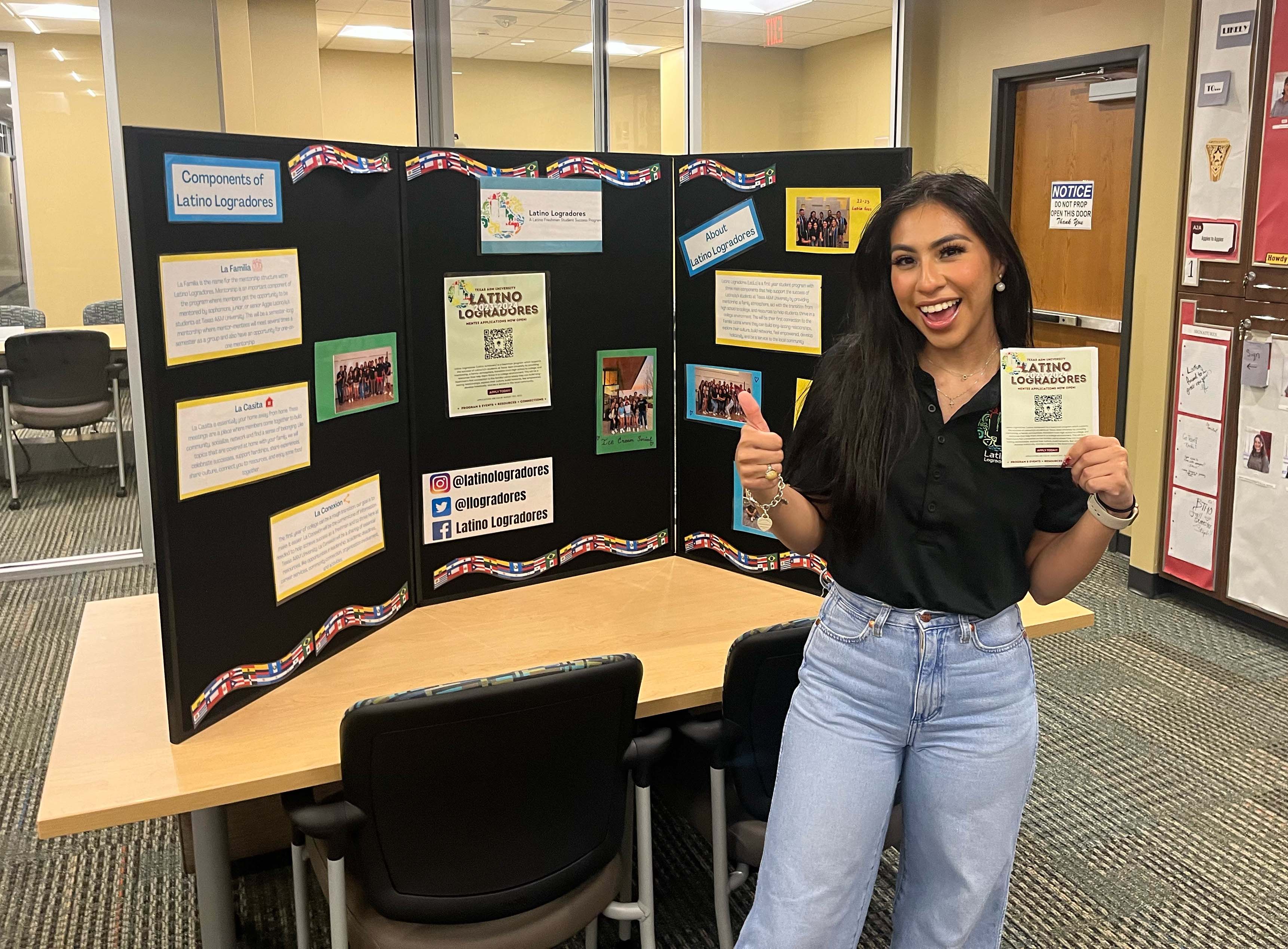 Texas A&amp;M women's and gender studies major Odyssey Olmos, standing by an exhibit for Latino Logradores in the Student Programs Office within the Memorial Student Center