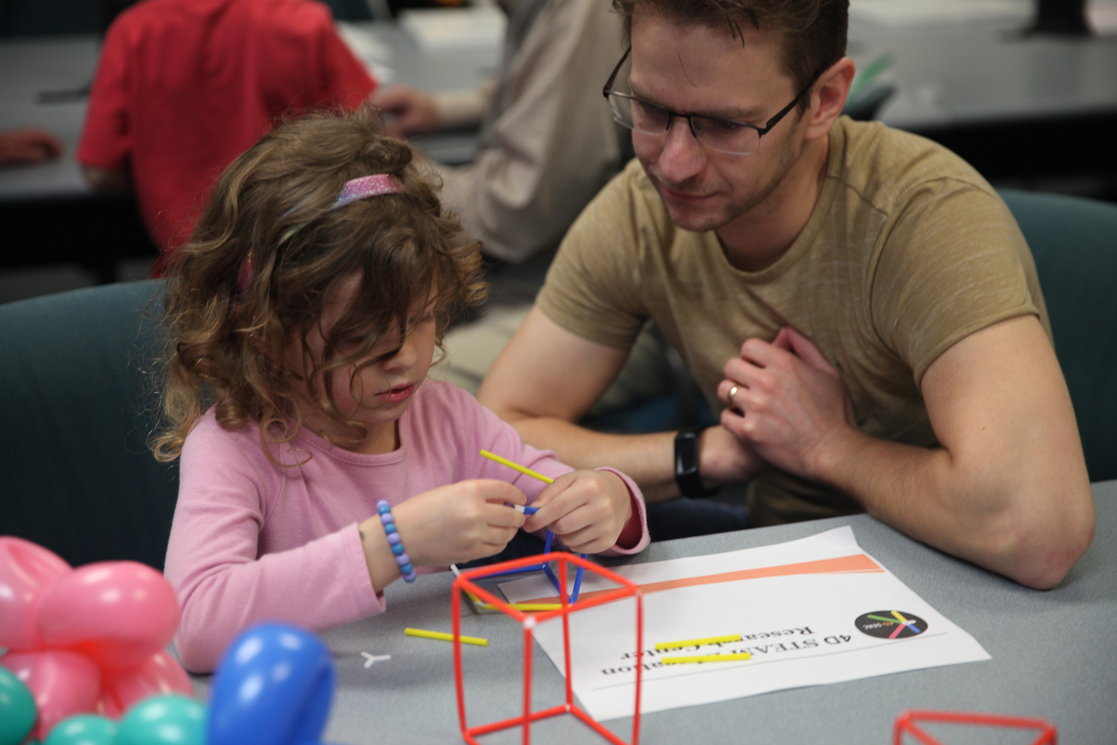 A father and his daughter participate in a craft event at the 2023 Texas A&amp;M University Math and Stat Fair