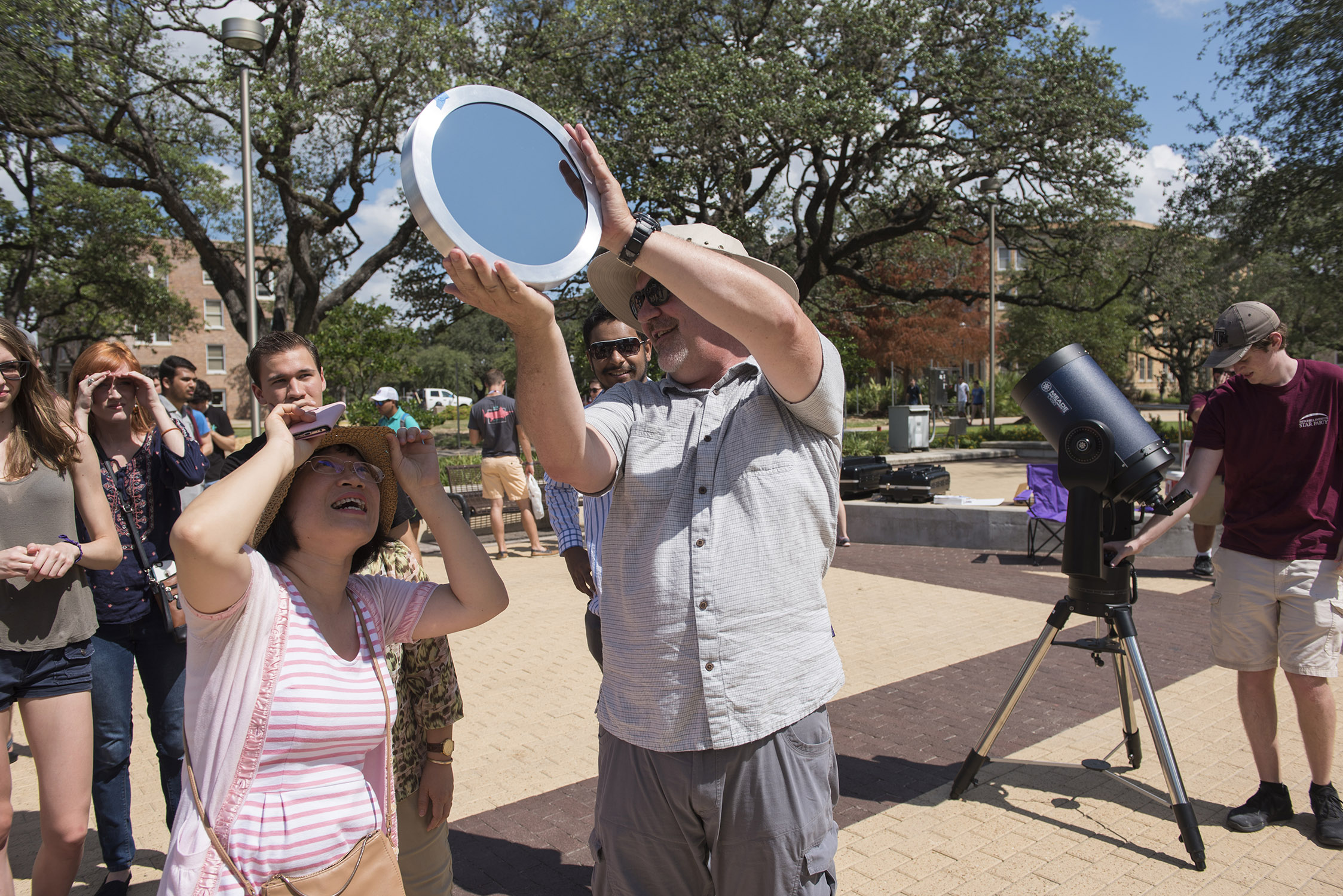 Texas A&amp;M University astronomer Darren DePoy assists a line of participants in viewing the solar eclipse from Rudder Plaza on the Texas A&amp;M campus on August 21, 2017