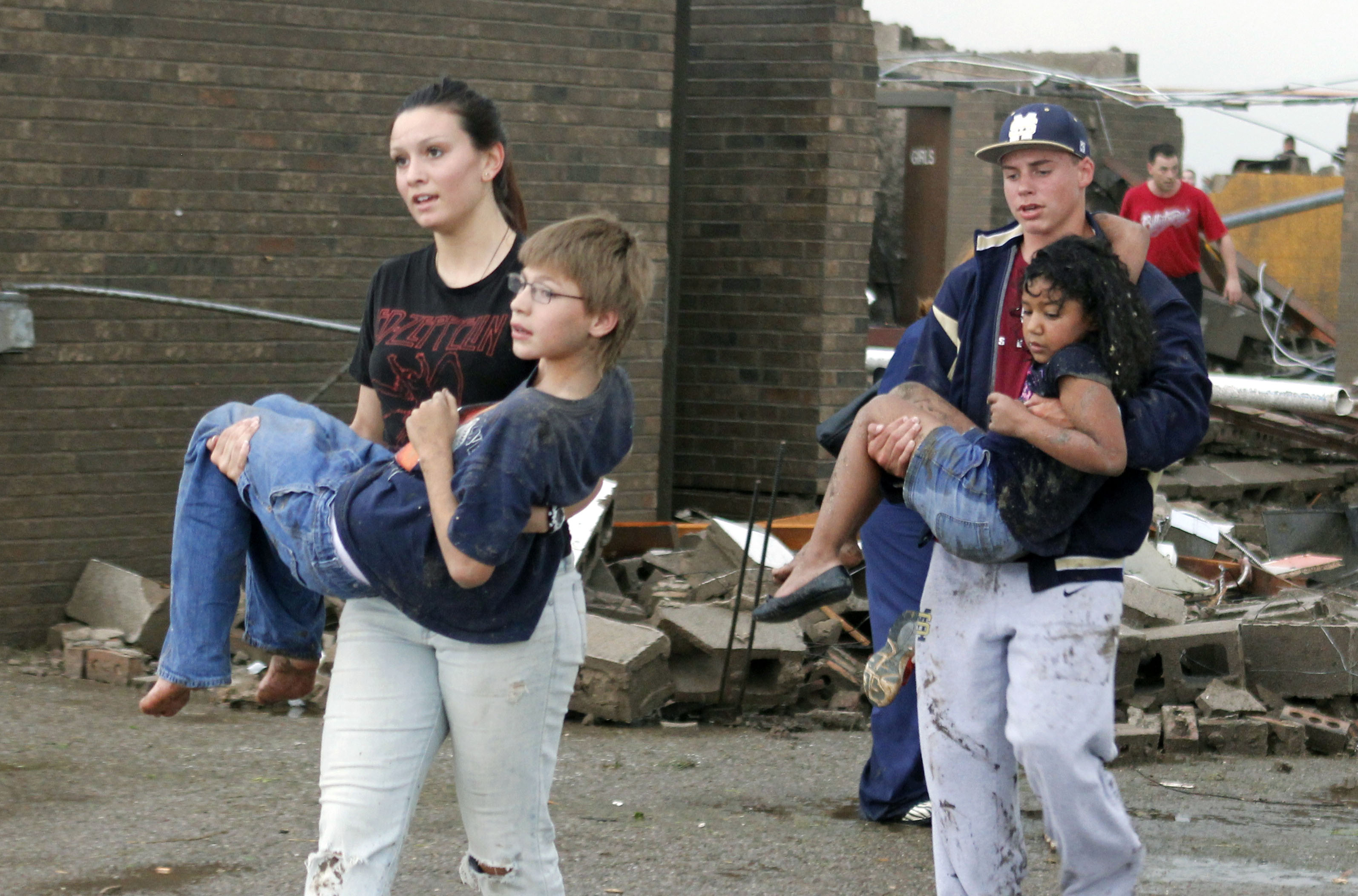 Eight-year-old Aria Vargyas, being carried out of the rubble along with a fellow student at Briarwood Elementary School, which was destroyed by an EF-5 tornado that struck Moore, Oklahoma, on May 20, 2013