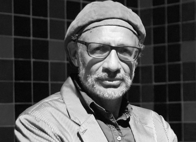 Black and white close-up headshot of man with a beret and sunglasses