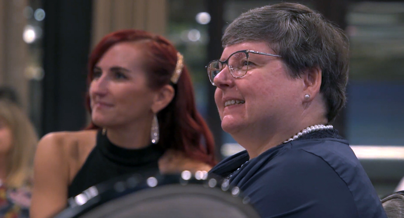 Texas A&M University oceanography professors Chrissy Wiederwohl and Shari Yvon-Lewis listen to a speaker while seated at a table at the Texas A&M Oceanography 75th Anniversary Gala, held September 20, 2024, at The George Hotel in College Station, Texas