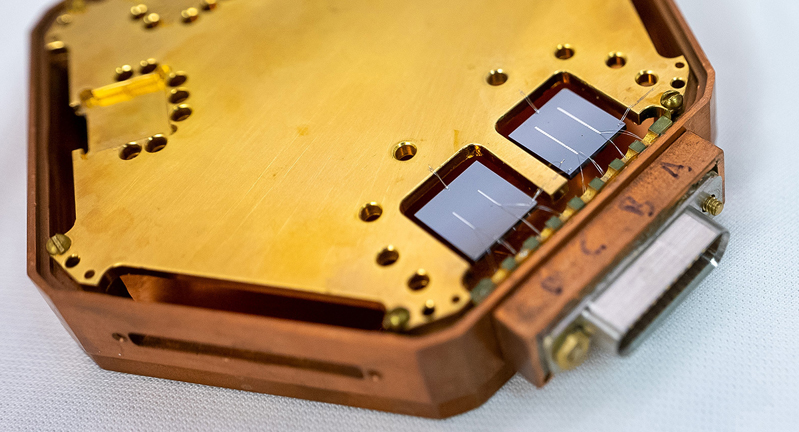 Close-up of a hexagonal structure holding two square chips, each with two reflective lines.