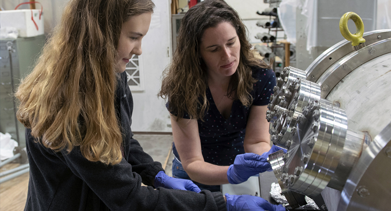 Two female researchers work to calibrate equipment settings within the Cyclotron Institute at Texas A&M University.