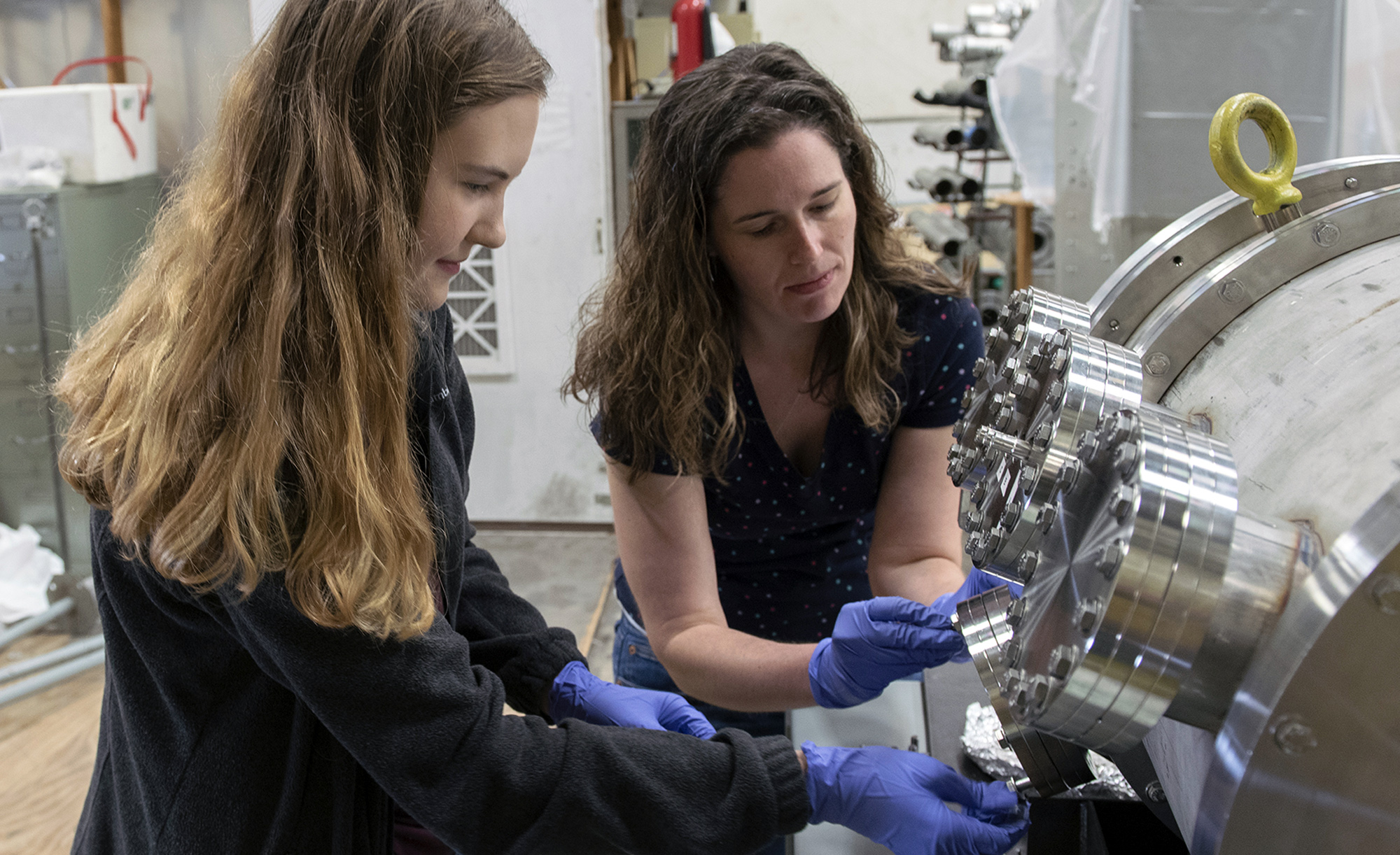Two female researchers work to calibrate equipment settings within the Cyclotron Institute at Texas A&M University.