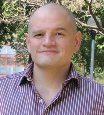 Dr. Ramses Humberto Mena Chavez smiling outdoors with trees in the background.