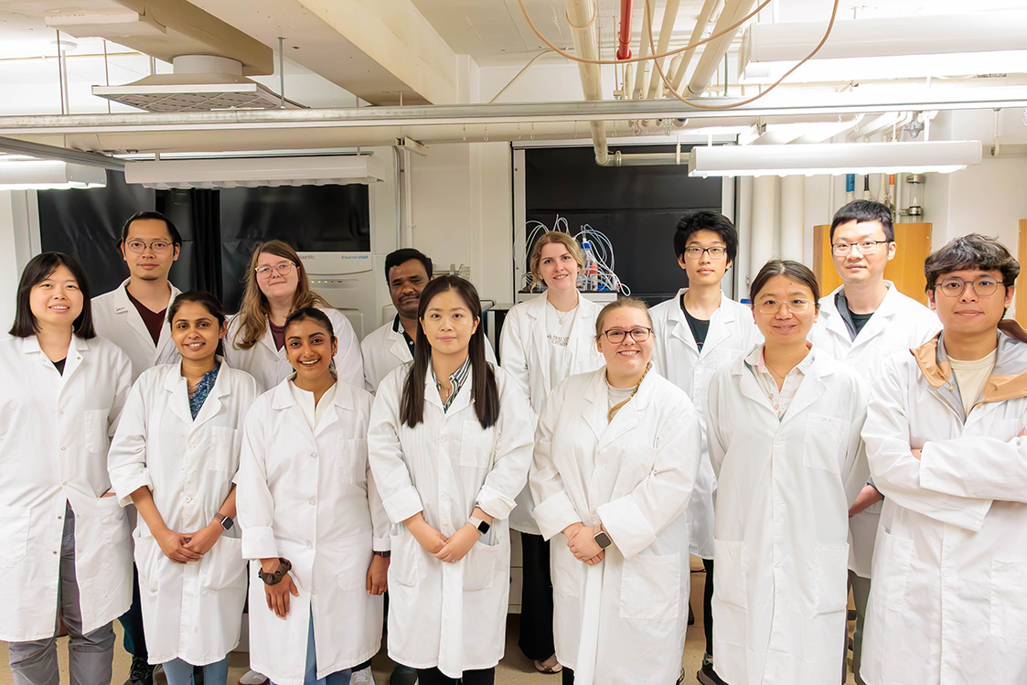 A group shot of the Yan Research Group in lab coats.