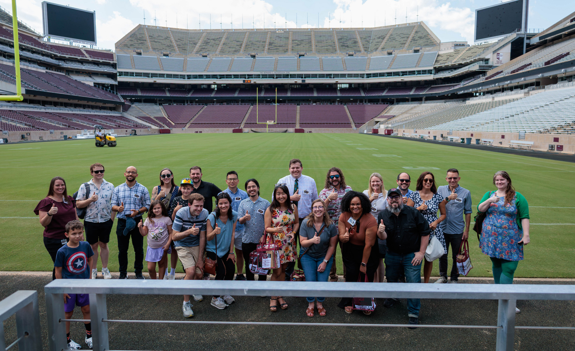 A group of new faculty stand on Kyle Field.