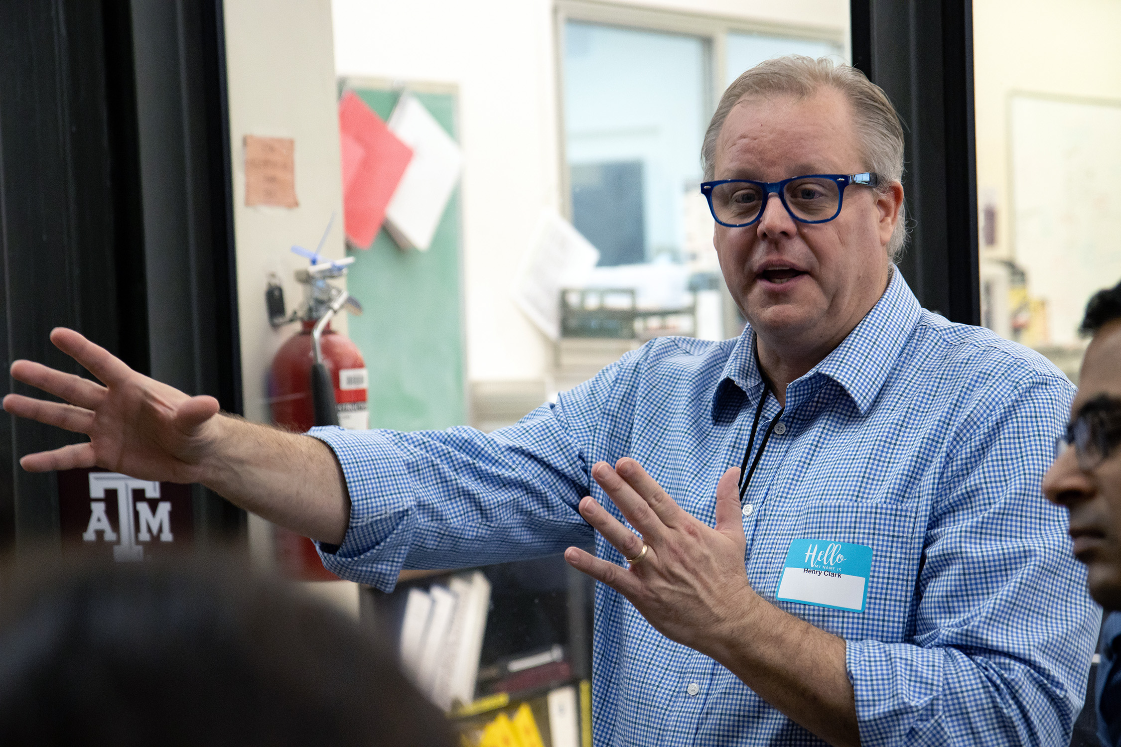 Texas A&amp;M University accelerator physicist Henry Clark gestures animatedly while speaking with visitors to the Cyclotron Institute.