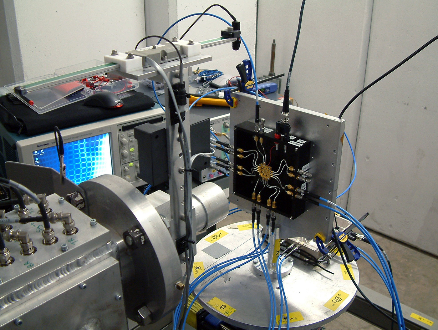 Close-up of an array of electronic equipment, featuring oscilloscopes, cables, a complex circuit board and a small computer monitor with various knobs and dials within the Cyclotron Institute at Texas A&amp;M University.